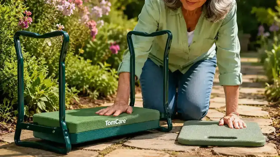 Person gripping the padded side handles of a TomCare garden kneeler bench to push themselves up from a kneeling position in a garden bed