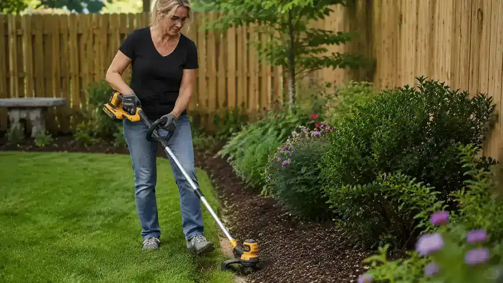 Clean crisp lawn edge along a concrete driveway showing the result of cordless trimmer edging